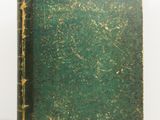 an old green book sitting on top of a white surface