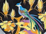 a plate with a bird painted on it on a table