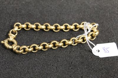 a close up of a gold chain bracelet with a tag on it