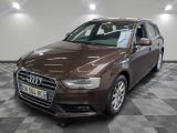 L'Audi marron est garée sur un sol à damier dans un garage.