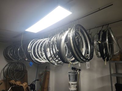 de nombreuses jantes suspendues à un support dans un garage