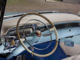 dashboard of a classic car with a steering wheel and steering knobs