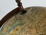an old globe with a wooden handle on a white surface
