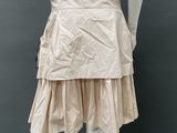 a close up of a mannequin wearing a beige dress with ruffles