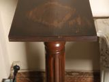 a small table with a wooden top on a carpet