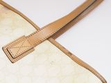 beige and white handbag with a leather strap on a white surface