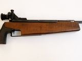 le fusil est posé contre le mur, à côté du mur