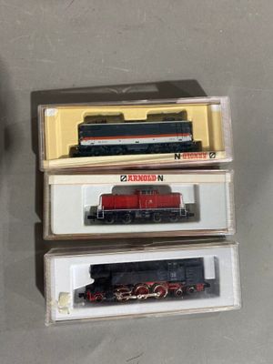 trois boîtes de petits trains empilées les unes sur les autres sur une table