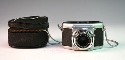 un appareil photo et un étui posés sur une surface blanche