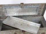a metal box with a lid open on a white surface