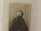 une vieille photo d'un homme barbu vêtu d'un manteau noir