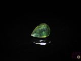 a close up of a green gemstone on a black surface