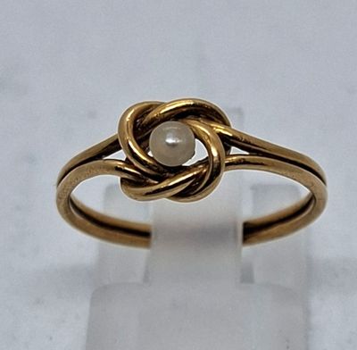 une image représentant une bague en or ornée d'une perle au centre