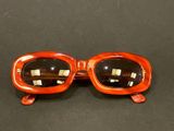 an image of a pair of orange sunglasses on a table