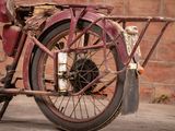 a old red motorcycle parked in front of a brick wall