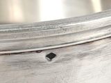 an antique silver plate with a black diamond on the rim