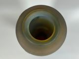 a close up of a vase on a white table