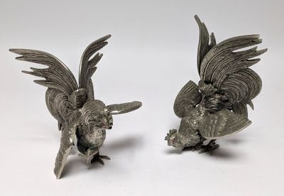 pair of antique silver plated parrot figurines on white background