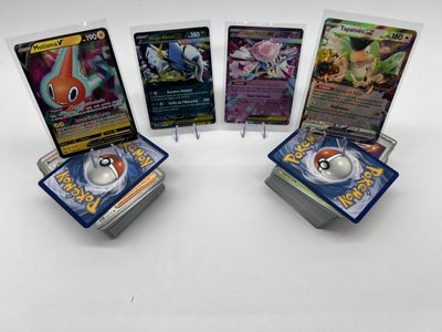 Quatre cartes Pokémon sont posées les unes sur les autres sur une table.