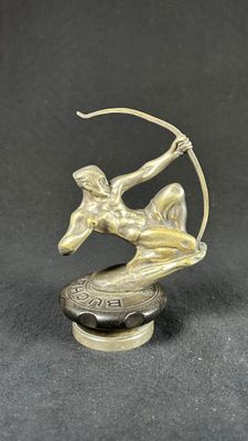 bronze statue of a woman with a bow and arrow on top of a coin