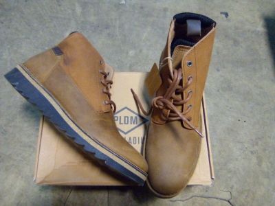 pair of men ' s brown boots sitting on top of a cardboard box