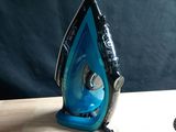 a blue and black iron sitting on a wooden table