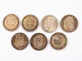 six pièces de monnaie britanniques différentes posées sur une surface blanche, sur fond blanc