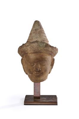 statue représentant la tête d'une personne coiffée d'un chapeau, posée sur un socle en bois