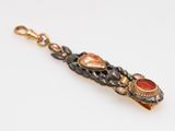a close up of a gold and red stone bracelet on a white background