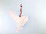 une femme en robe blanche qui saute en l'air