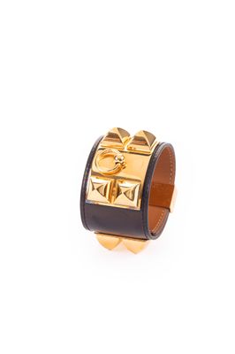 une image représentant une bague noire et dorée ornée d'une croix