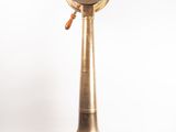 an old fashioned brass clock on a wooden stand on a white background