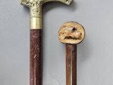 two old canes with a wooden handle sitting next to each other on a table