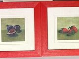 two framed pictures of strawberries on a red shelf
