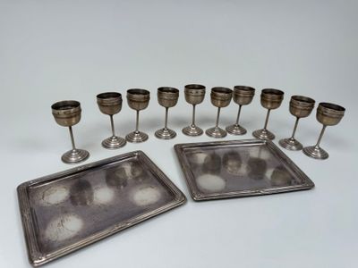 several silver plated wine glasses and trays on a white surface