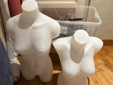 two white mannequins sitting on the floor next to each other