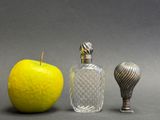 three different types of perfume bottles next to an apple