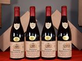 three bottles of red wine are lined up on a red table