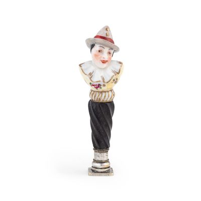 une figurine représentant un clown avec un chapeau et une chemise rayée