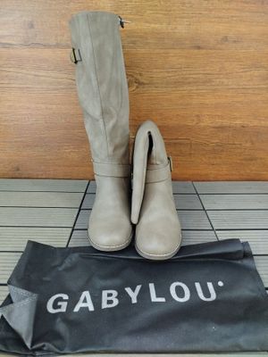 une paire de bottes grises posée sur un sac noir