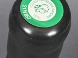 a close up of a black bottle with a green label on it