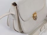 the white purse is sitting on a white surface