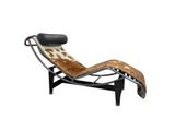 a brown and white cowhide chaise lounger with black legs