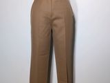 brown pants on a mannequin stand against a white wall