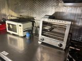 two toasters and a microwave sitting on a kitchen counter