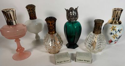 Plusieurs vases en verre sont alignés sur une surface blanche