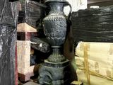 a large black vase sitting on a table in a warehouse