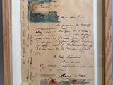 une vieille lettre manuscrite est exposée dans un cadre en bois