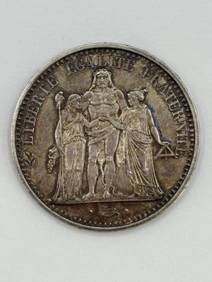 an old silver coin with a woman and two men on it