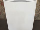 a white dishwasher sitting on top of a wooden stand